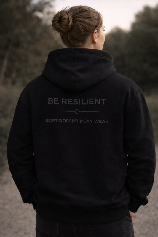 Back view of the Be Resilient premium black hoodie featuring the embroidered "Soft Doesn't Mean Weak" affirmation.